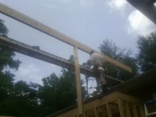 Carpenter setting a ridge beam over a new addition frame — Ice Dam Removal by Roofing Brothers in Rector